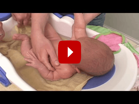 newborn being washed with organic shampoo newborn being washed with organic shampoo
